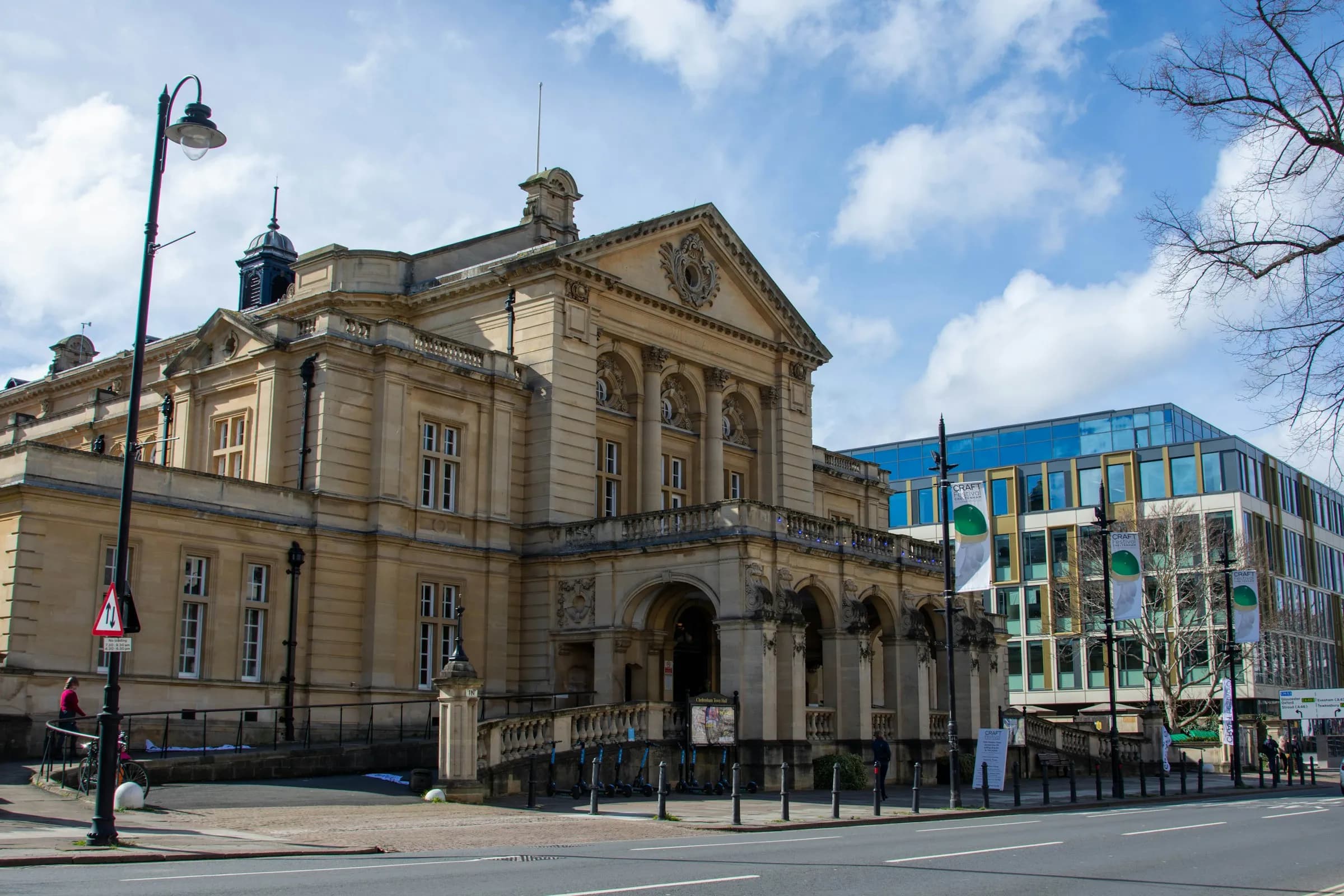 Victorian-era town hall with pedestrians on the street outside